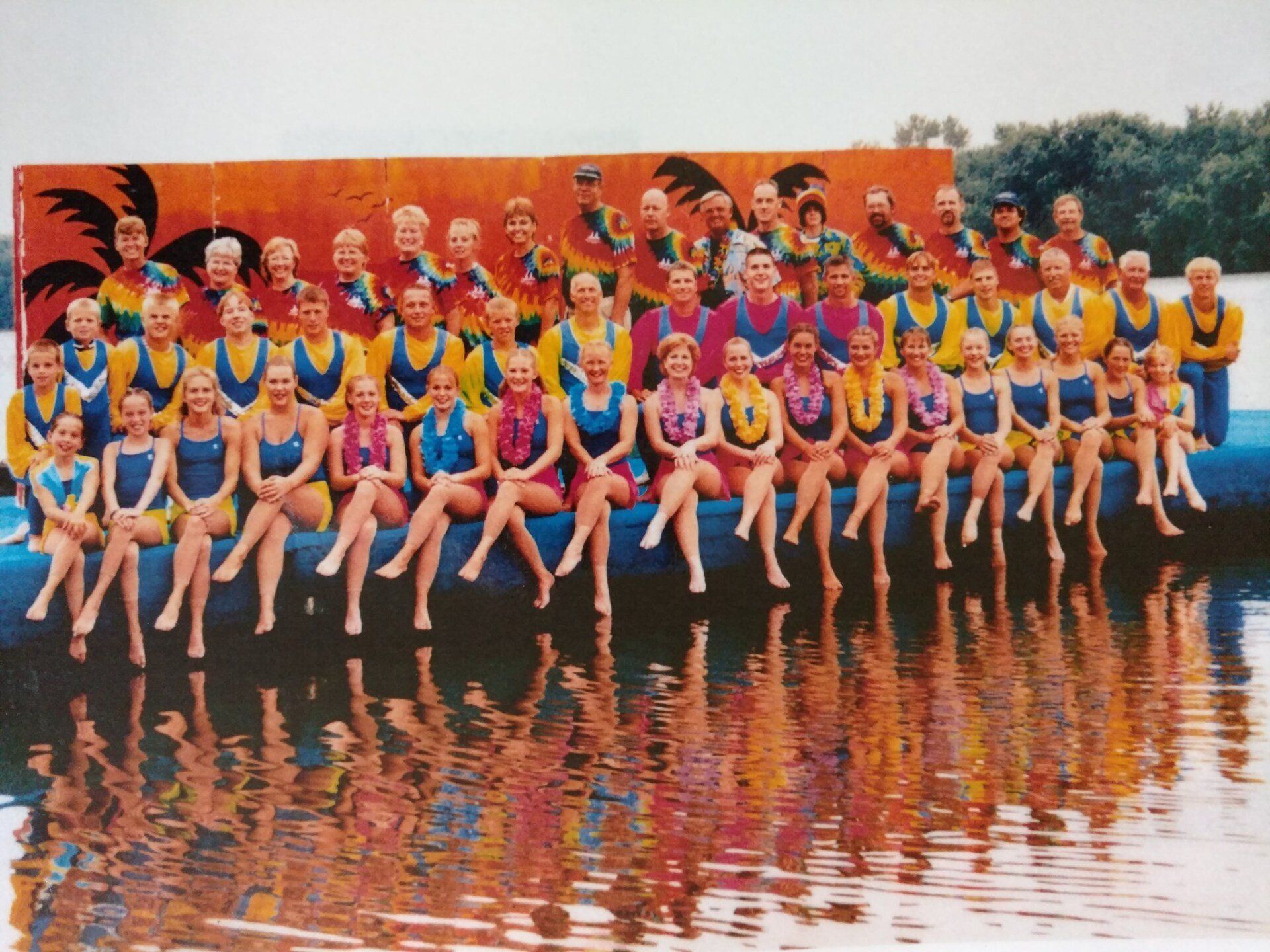 A large group of people are posing for a picture on the dock