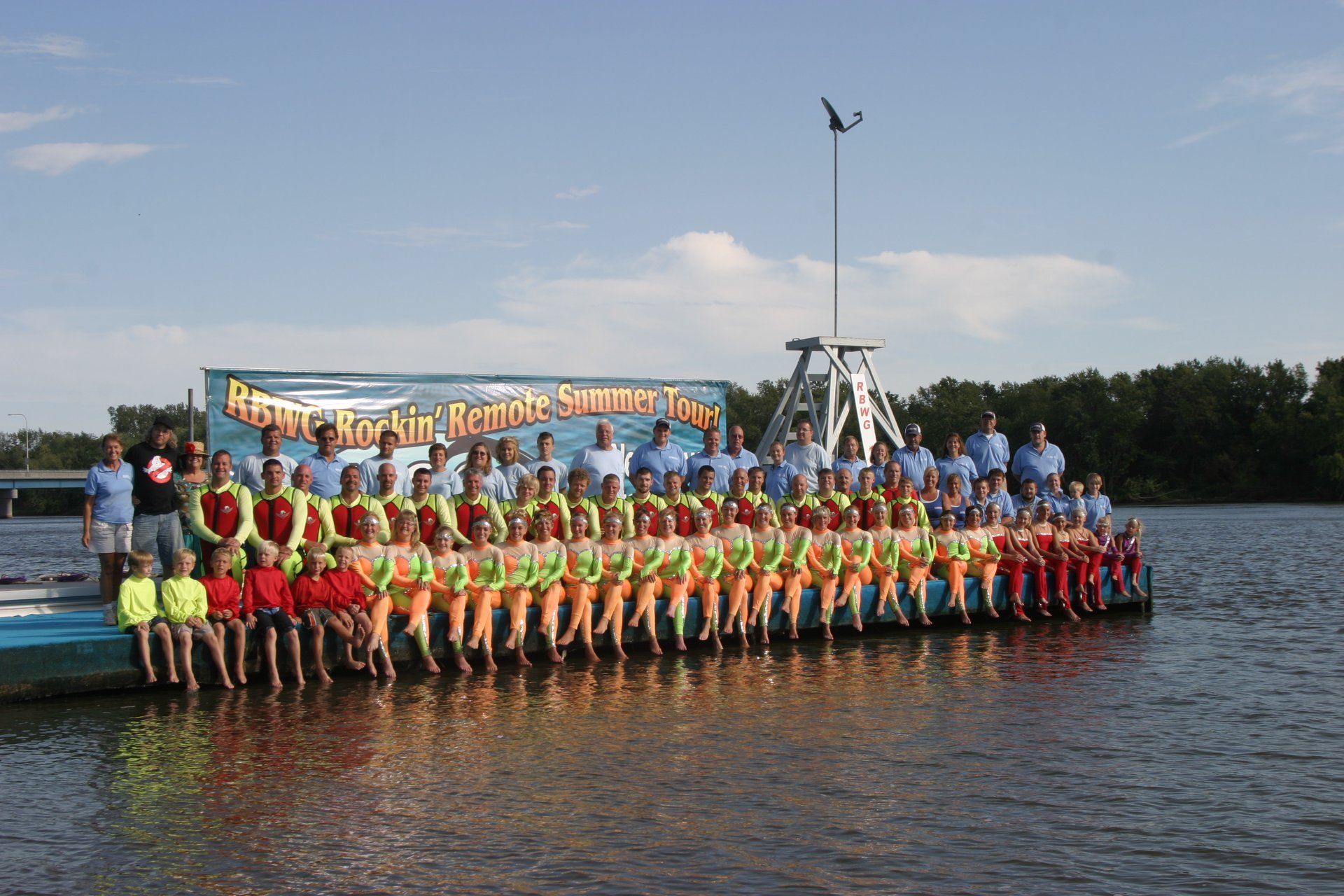 A large group of people are posing for a picture on a dock