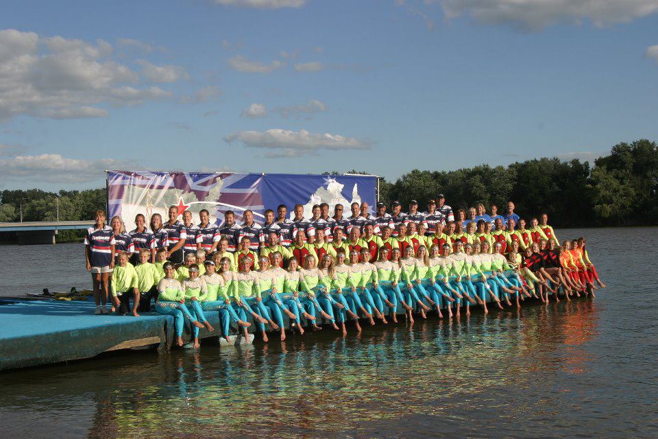 A large group of people are posing for a picture on a dock