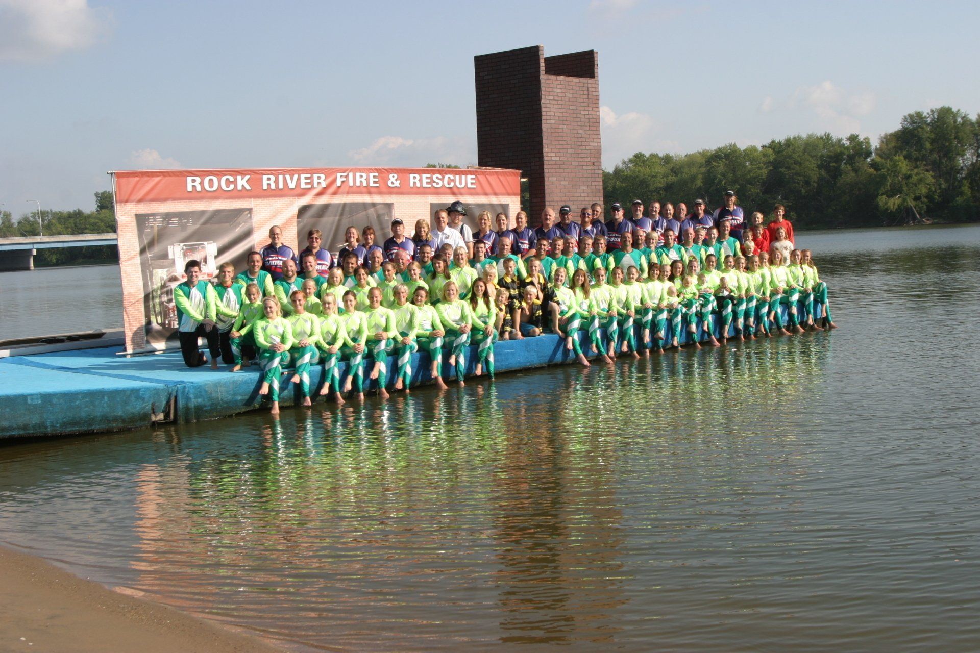 A large group of people are posing for a picture on a dock