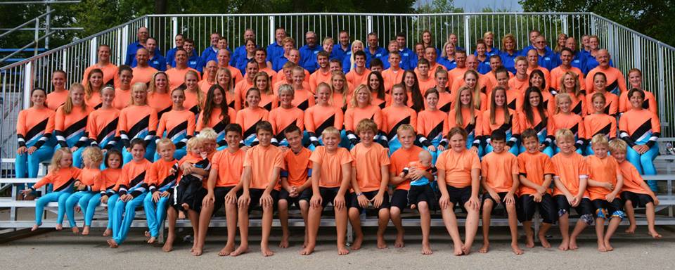 A large group of people are posing for a picture in the bleachers