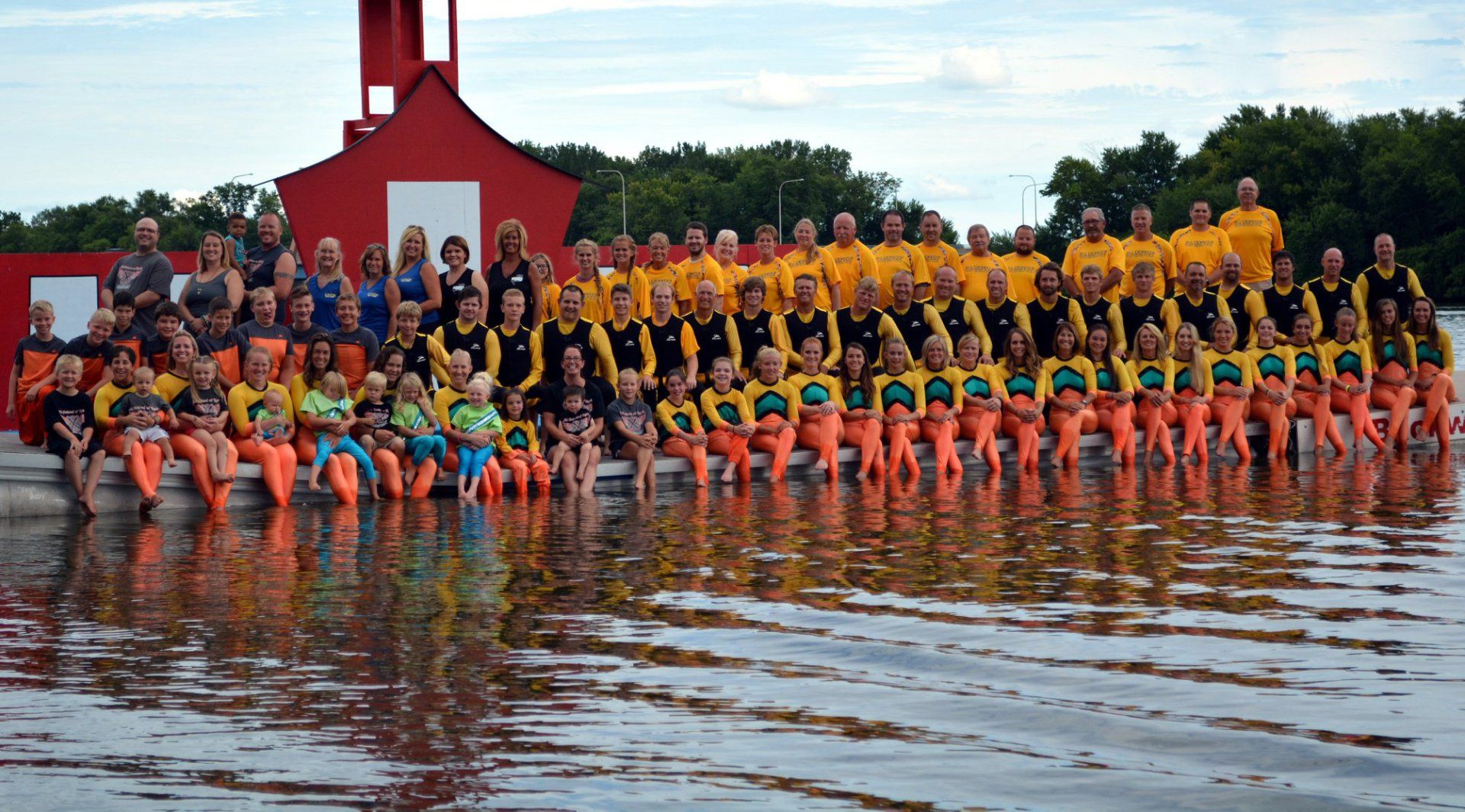 A large group of people are posing for a picture on the dock