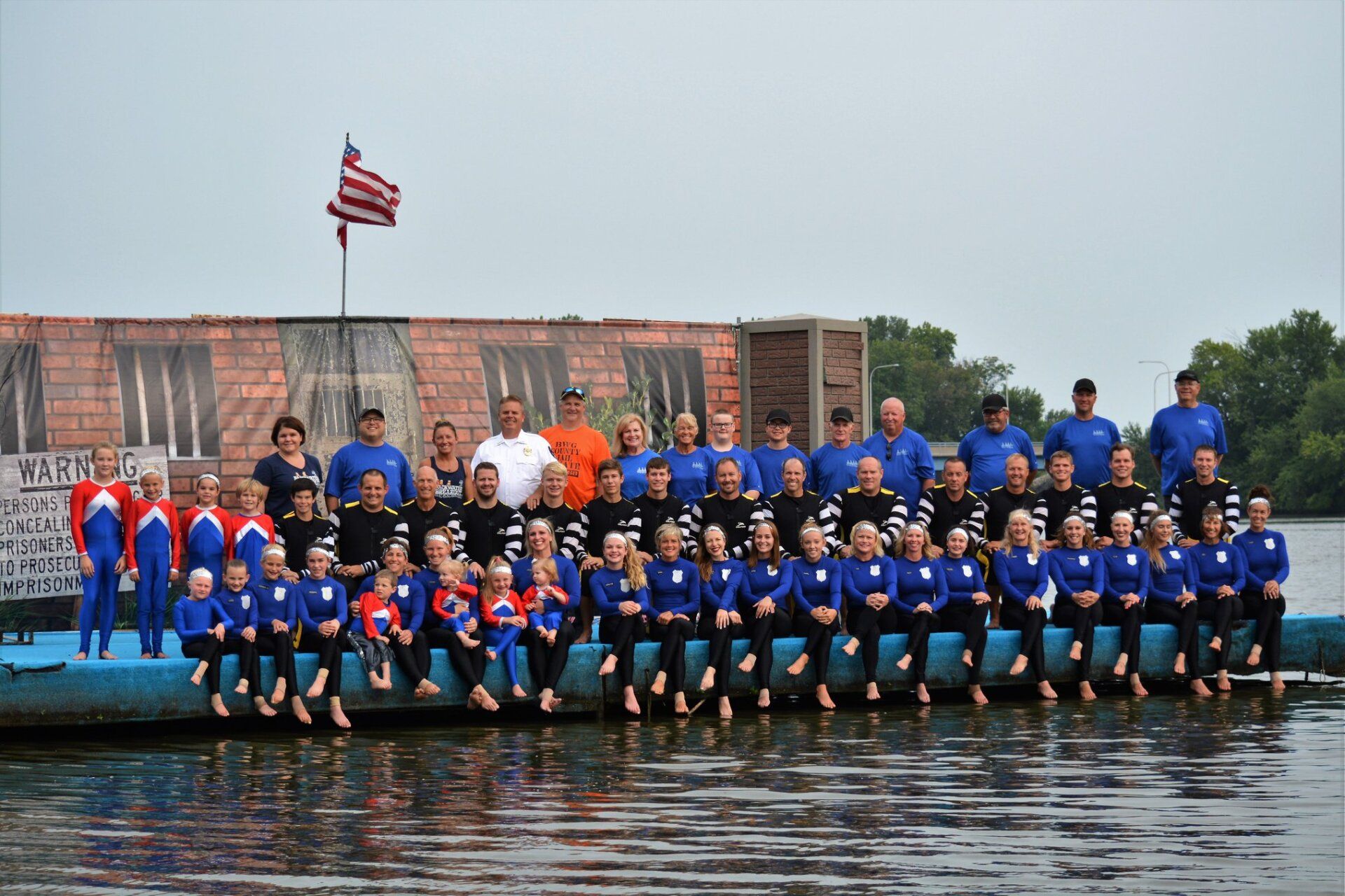 A group of people standing on a dock in the water