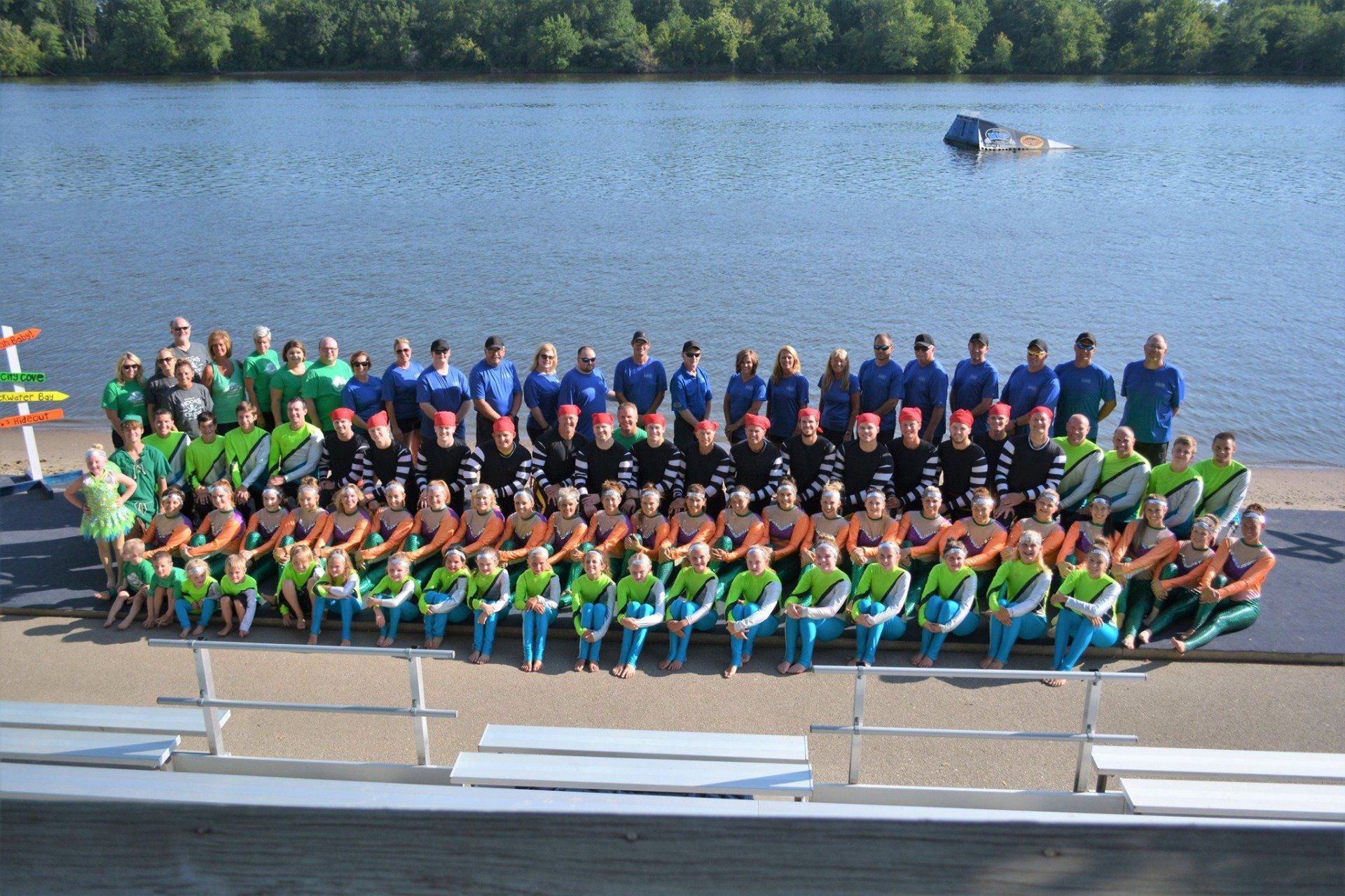 A large group of people are posing for a picture on the stage at the ski site