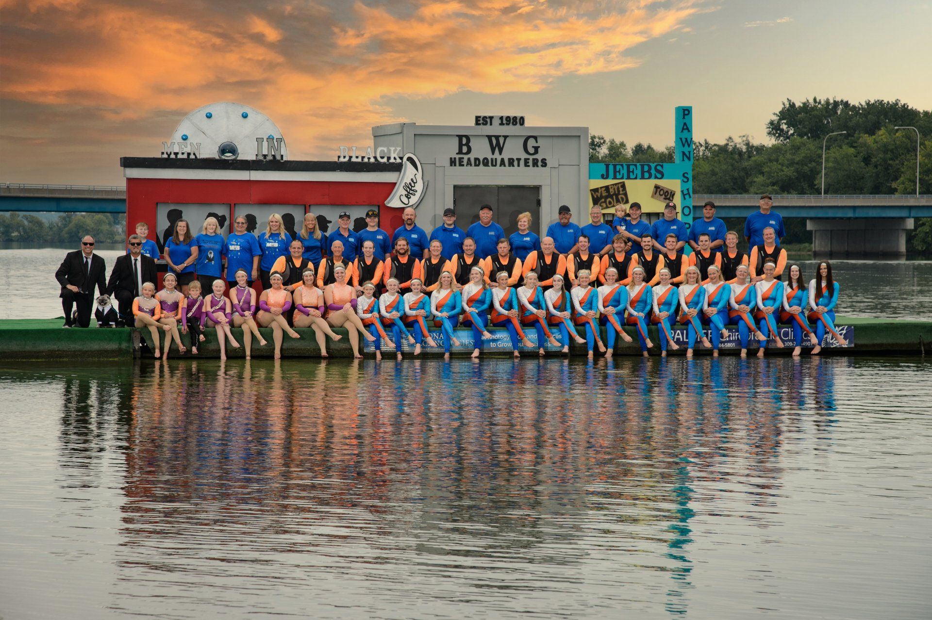 A group of people are posing for a picture in front of a building that says BWG