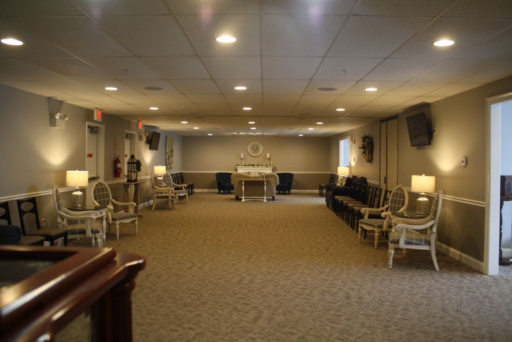 Large banquet hall with chairs lining the walls and a decorated altar at the far end.