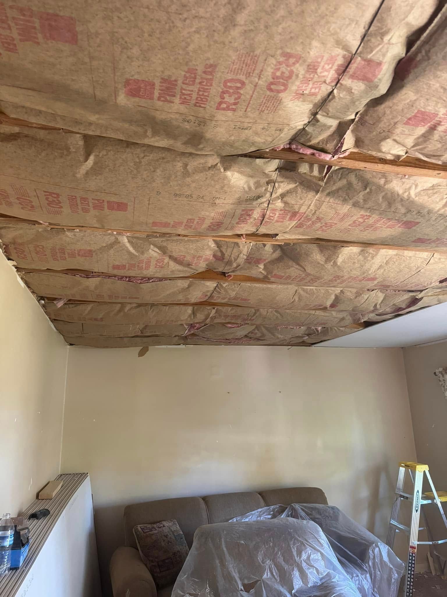 Room with exposed ceiling insulation.