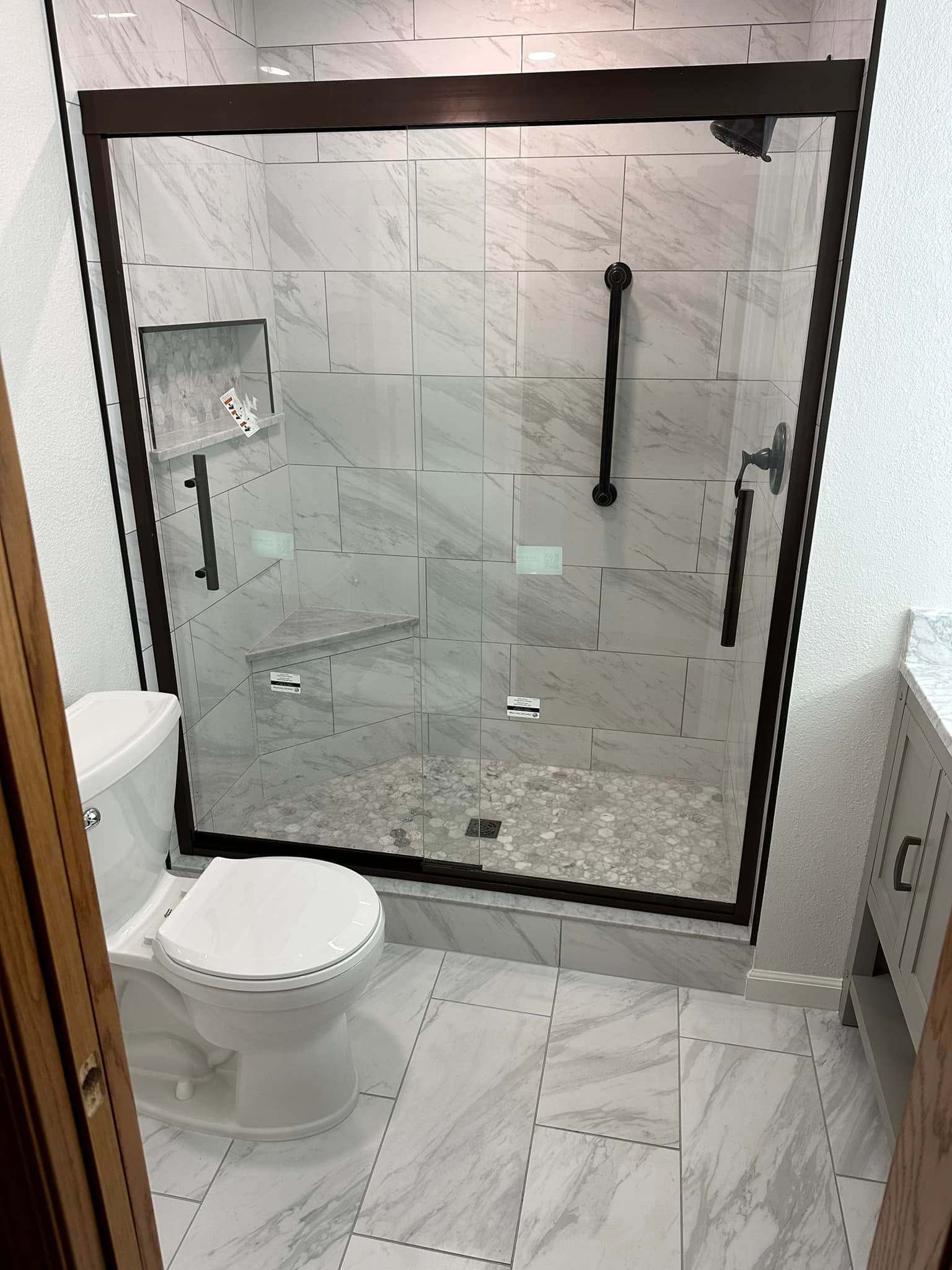 A bathroom with a toilet and a shower with a glass door.