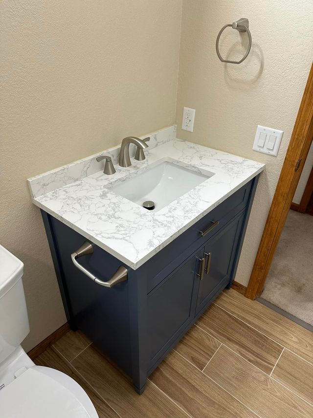 A bathroom with a sink , toilet and towel rack.