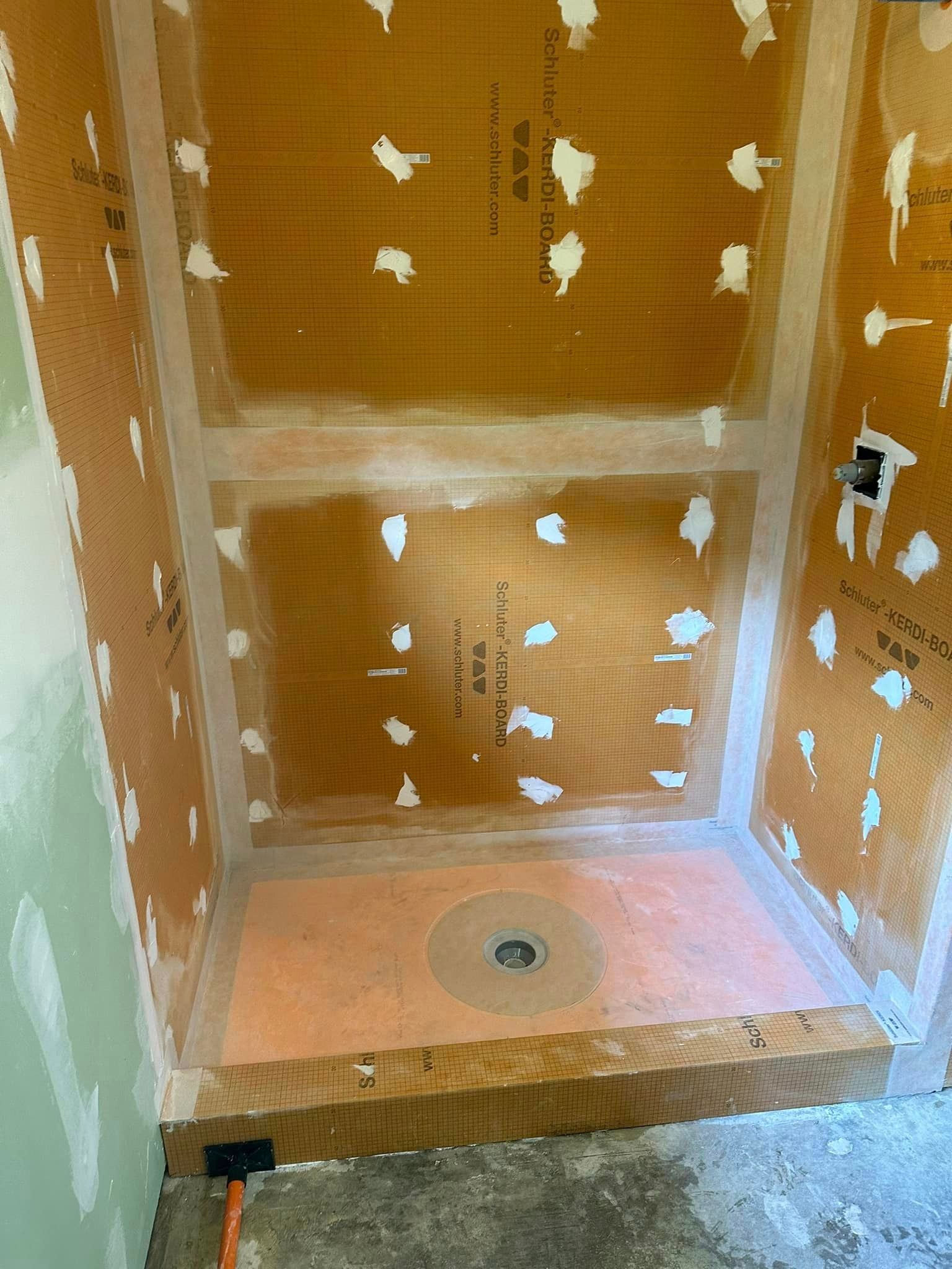 A shower stall is being built in a bathroom.
