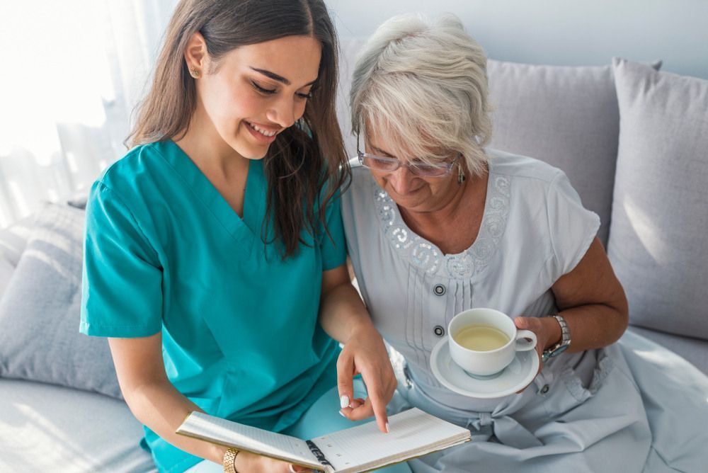 Nurse is Reading a Book to an Elderly Woman — Universal Nurse in Blackbutt, QLD