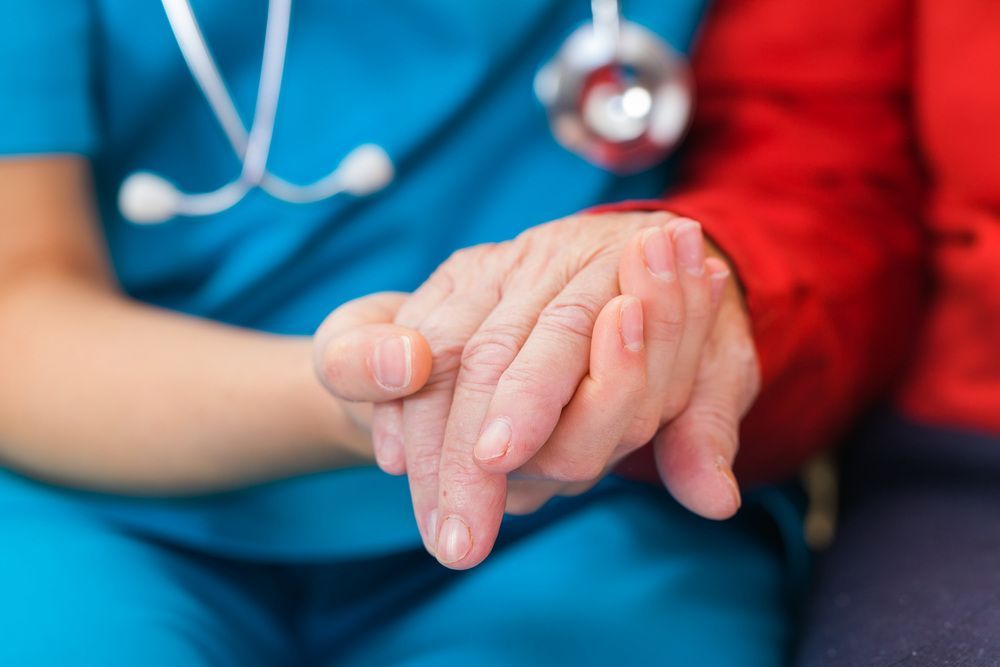 Nurse is Holding the Hand of an Elderly Woman — Universal Nurse in Blackbutt North, QLD