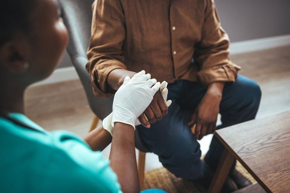 A Nurse Is Wrapping A Patient's Wrist With A Bandage — Universal Nurse in Kilcoy, QLD