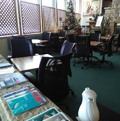 A restaurant with tables and chairs and a christmas tree in the background.