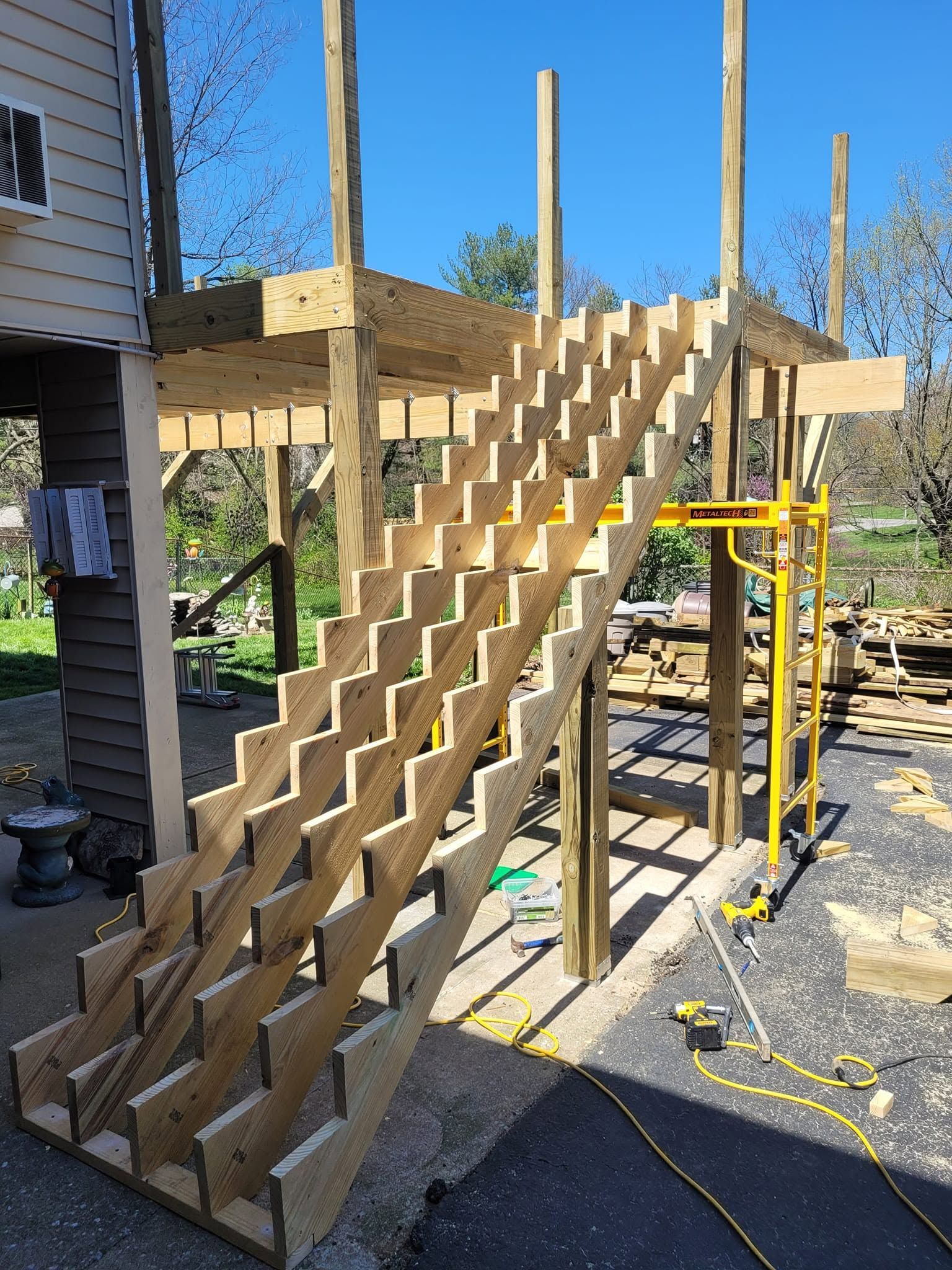 Partially built wooden staircase under construction on an outdoor deck frame