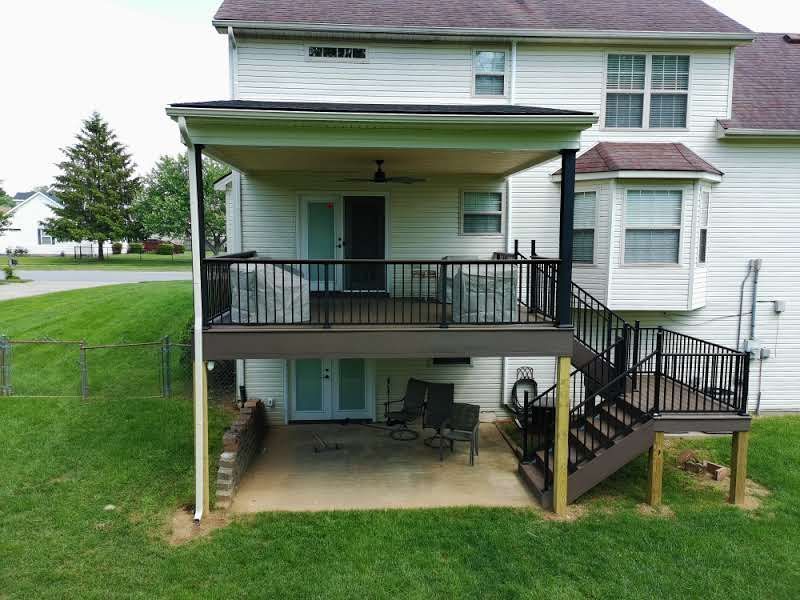 Two-story house with elevated porch, stairs, and covered patio underneath