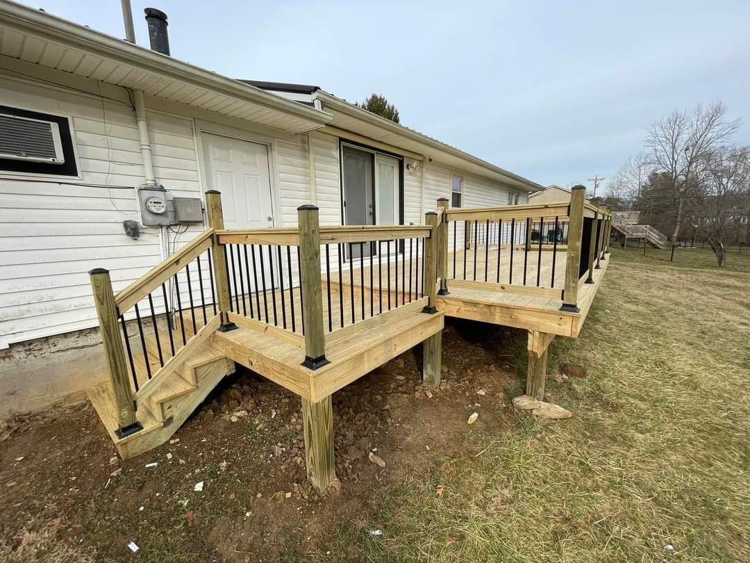 Wooden deck with railings attached to a house, overlooking a grassy yard