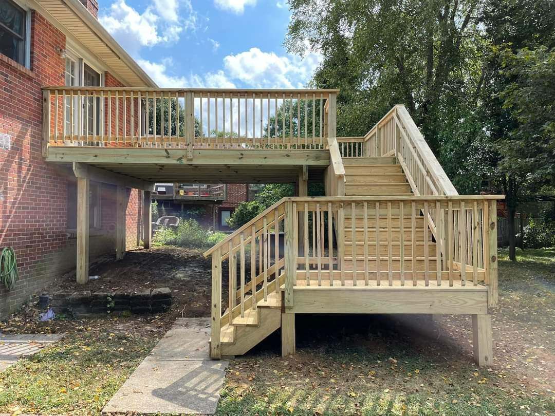 Wooden wheelchair ramp and deck beside a brick house, with stairs and railings outdoors.