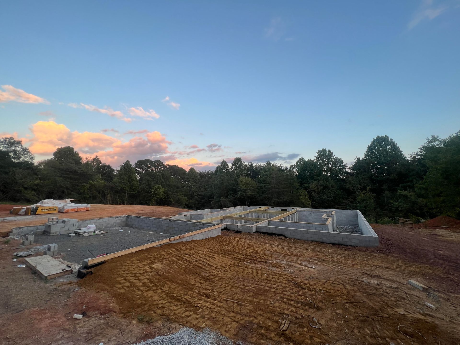 Construction site with a concrete foundation at sunset under a blue sky