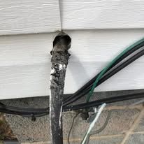 A close up of a pipe with wires coming out of it.