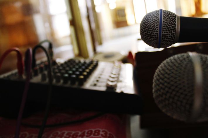 Microphones and mixing console on a table, indoors.