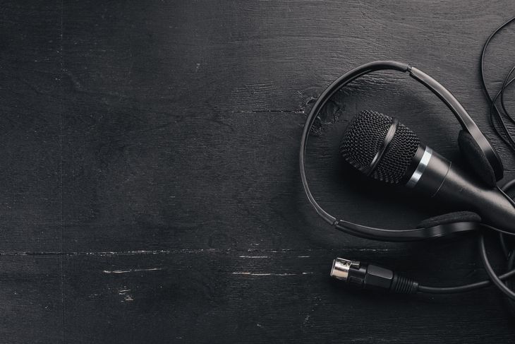 Black microphone and headset on a dark, textured surface.