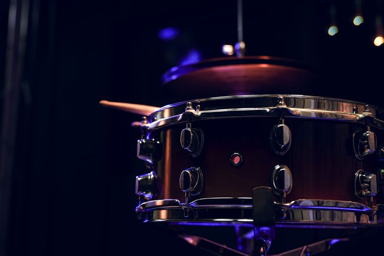 Close-up of a drum set with a drumstick resting on the snare drum.