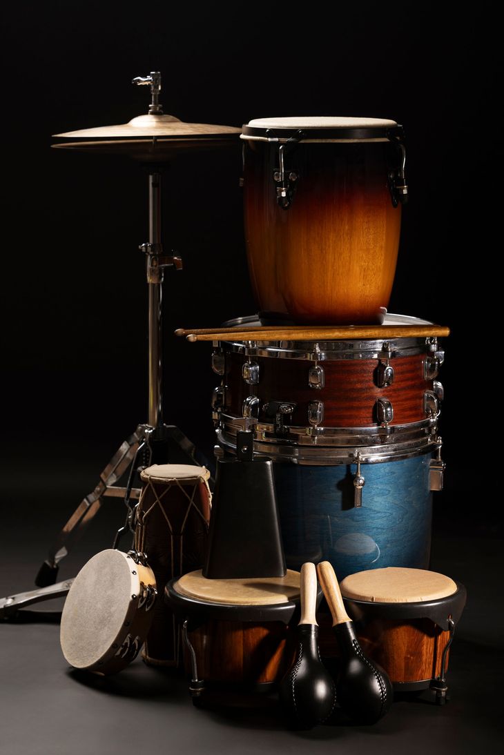 Drum set with various drums, cymbals, and drumsticks against a black background.