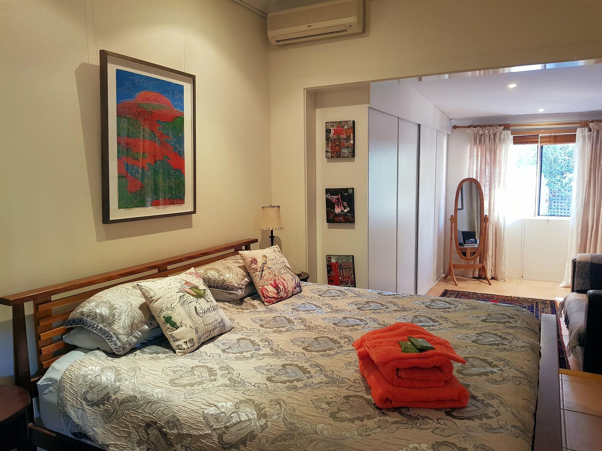 Bedroom with bed, art, window, and towels.