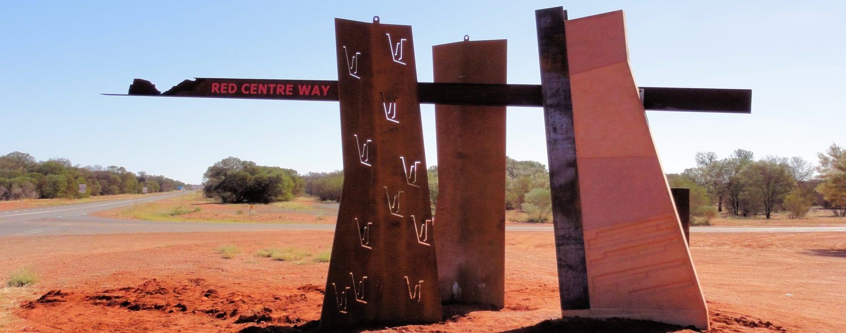 A roadside signpost for the Red Centre Way in the Australian outback.