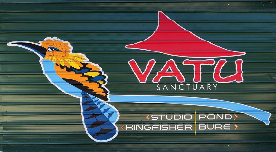 Sign for Vatu Sanctuary with a stylized bird, red roof design, and text