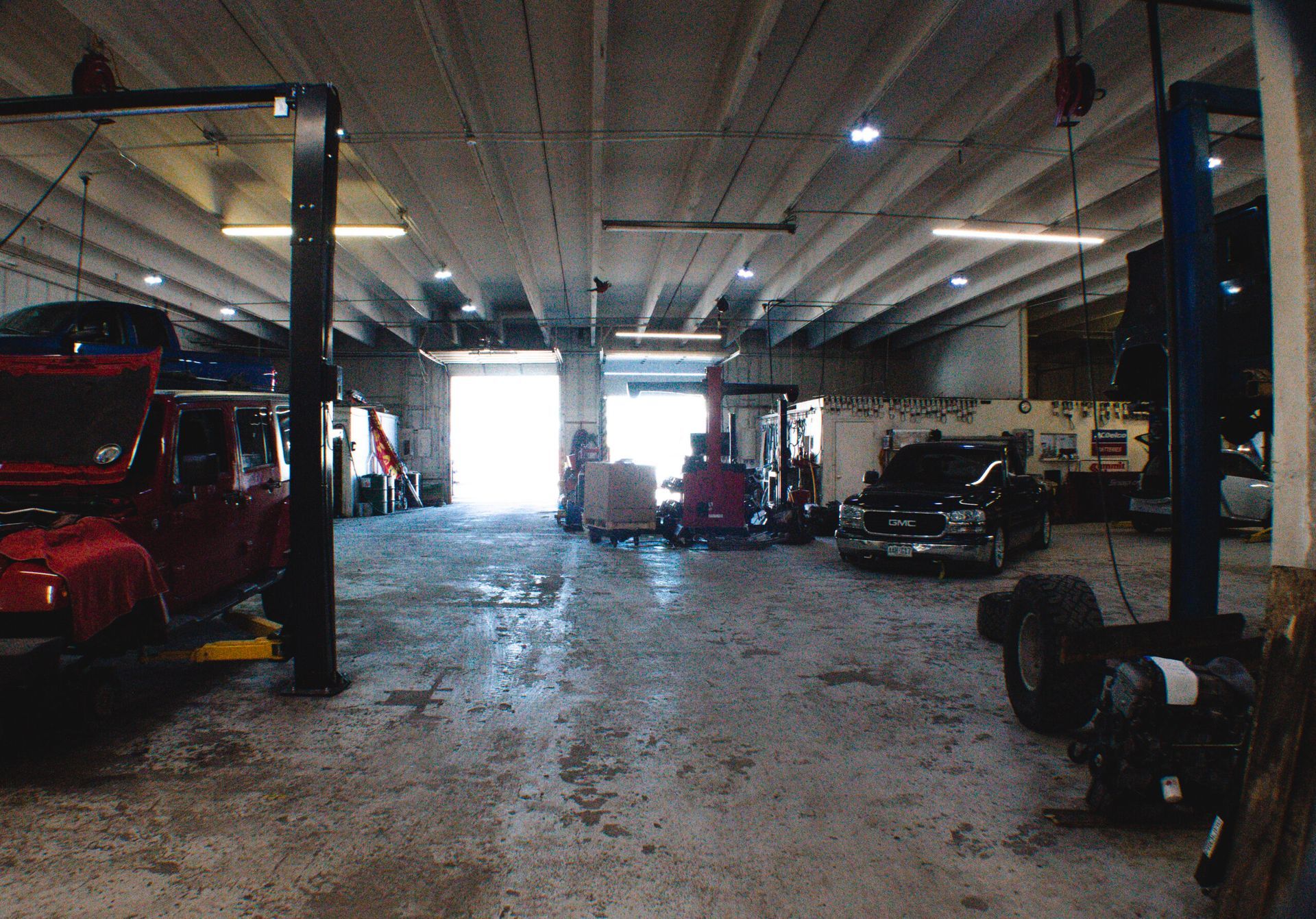 Auto repair shop interior with vehicles on lifts, tools, and bright overhead lights | Accurate Automotive Northglenn