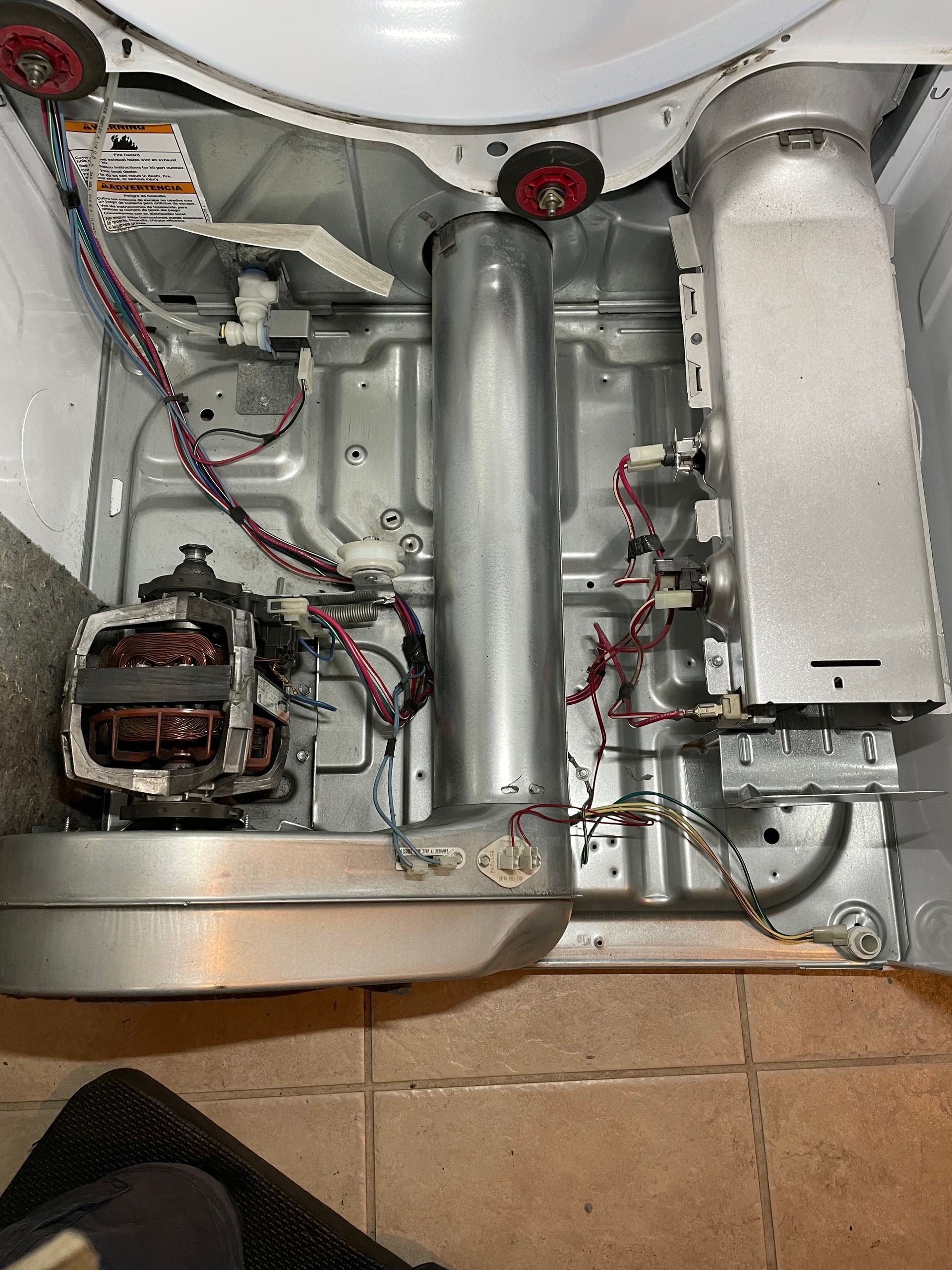 the inside of a washer and dryer with a lot of wires coming out of it . Fresno appliance repair