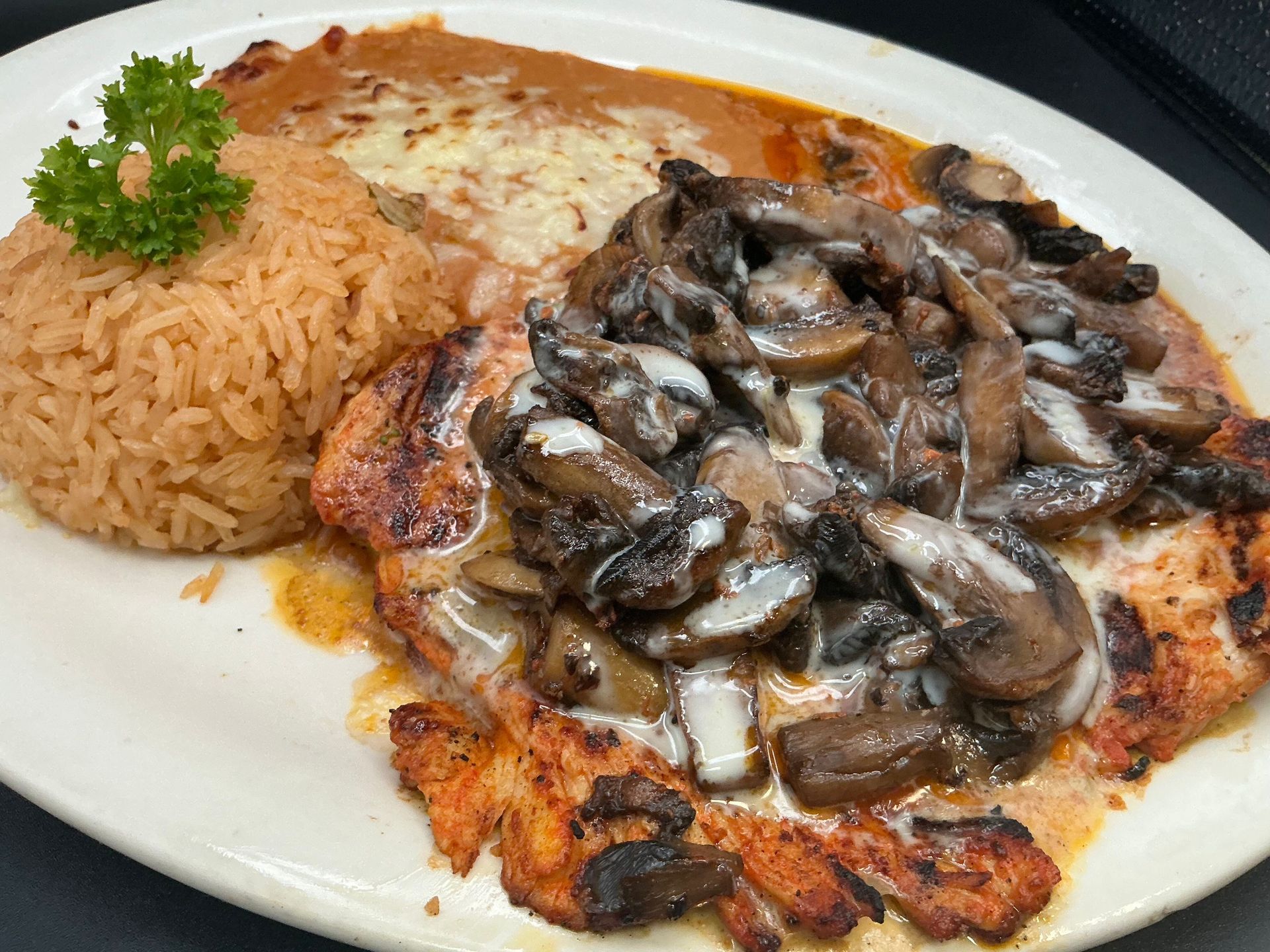 Chicken dish with rice, mushrooms, and cheese sauce.