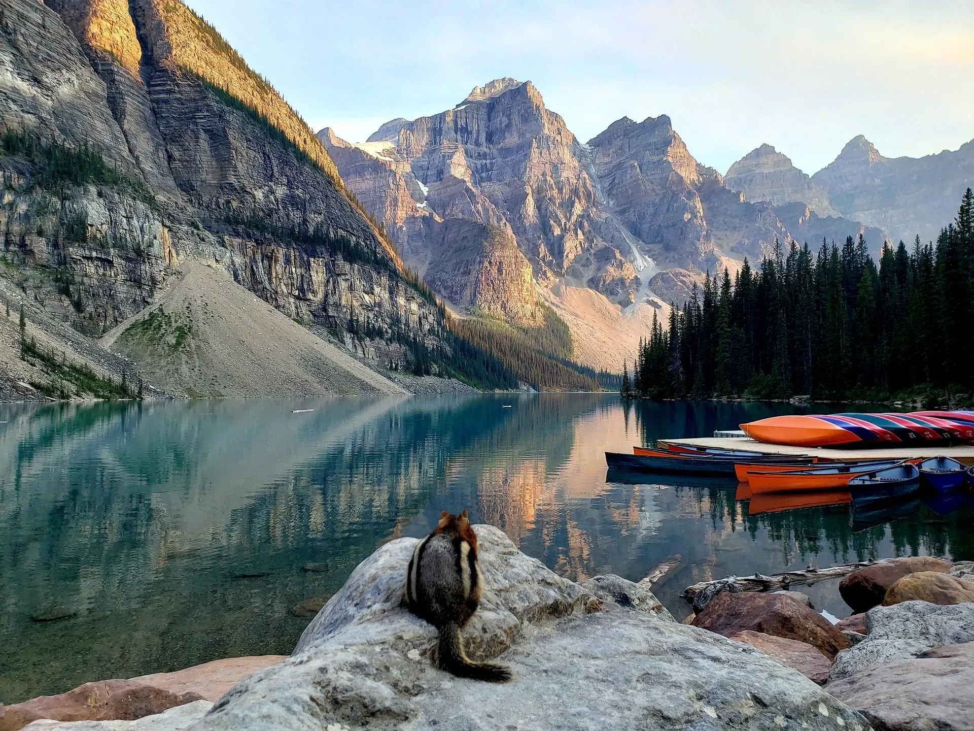 Sunset mountain reflected in a lake, with a bear and cub inset in the lower right.