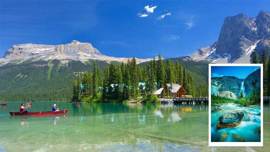 Alpine lake with red canoes, forested shore, and snow-capped mountains under a clear blue sky
