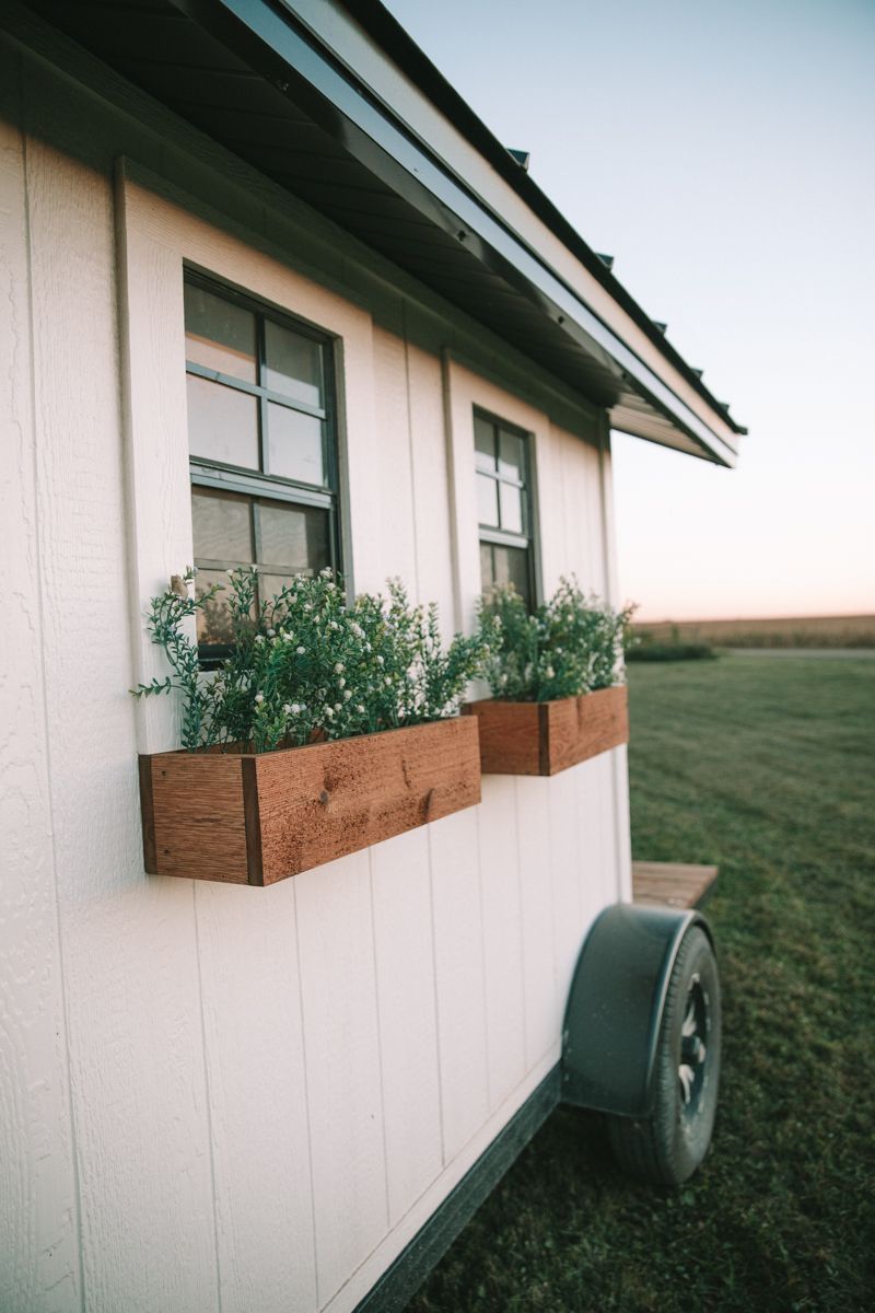 A white house with two wooden planters on the side of it