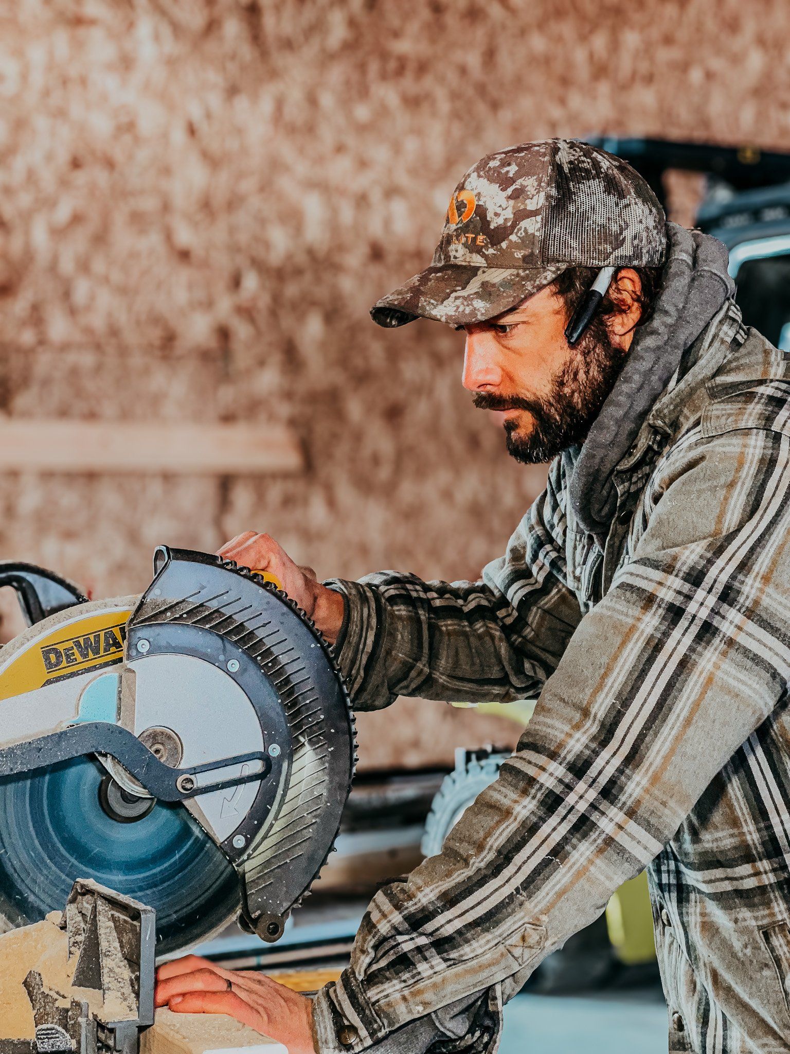 A man is cutting a piece of wood with a circular saw.