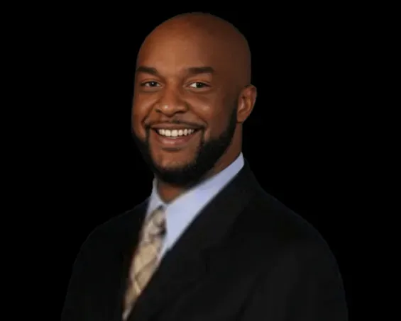 A man in a suit and tie is smiling for the camera