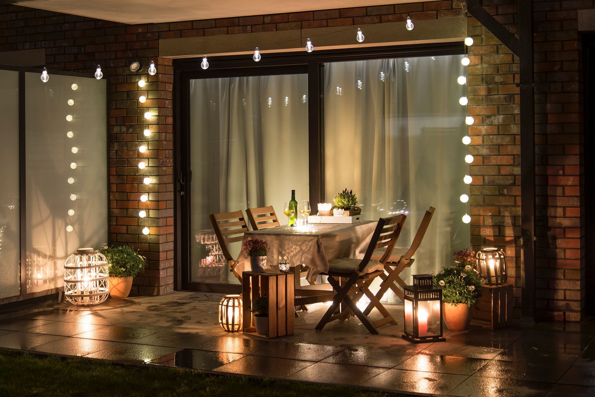 There is a table and chairs on the patio at night.