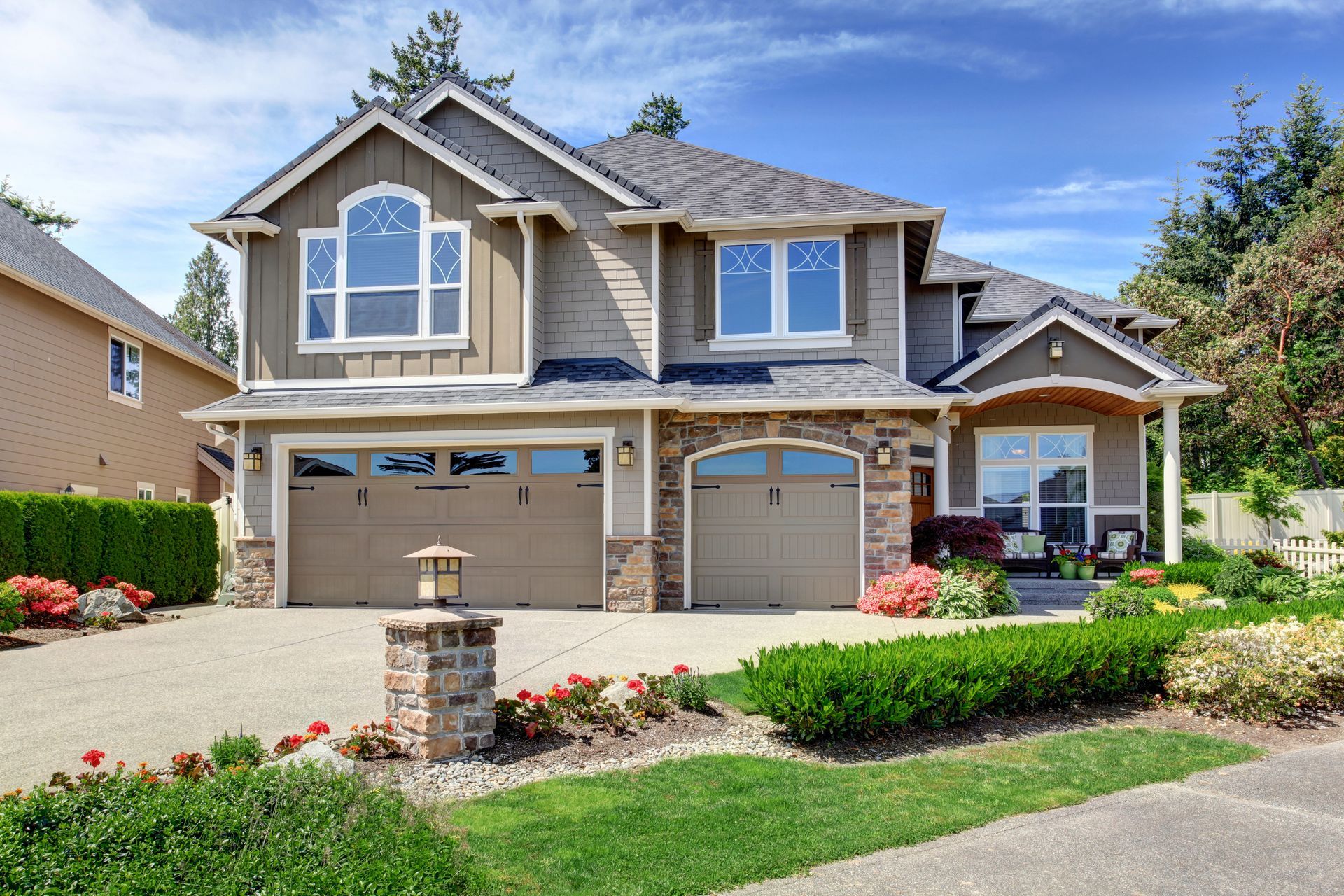 A large house with two garage doors and a large driveway