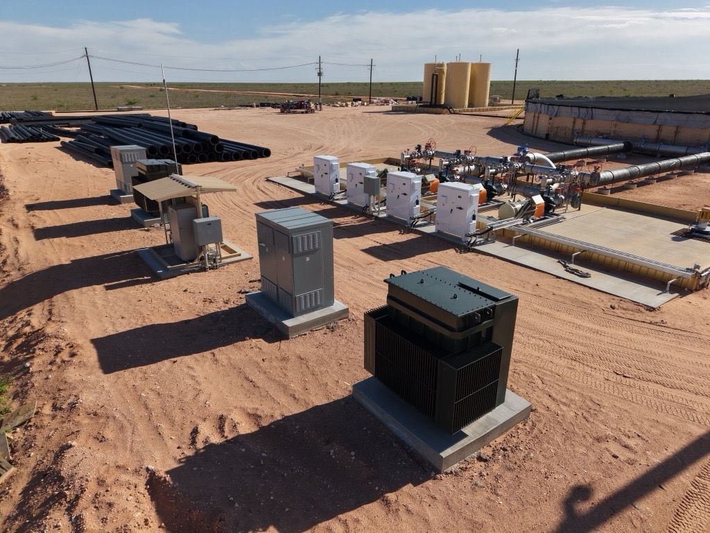 Electrical equipment installed on a sandy construction site under a clear sky.