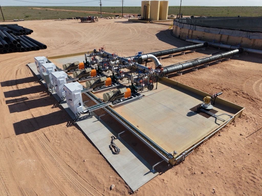 Industrial machine assembly on a desert site, with metal framework, pipes, and large panels.