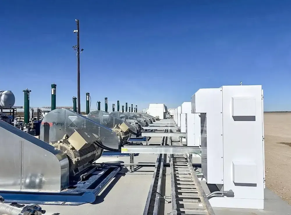 Industrial rooftop with HVAC equipment and white utility units under a clear blue sky