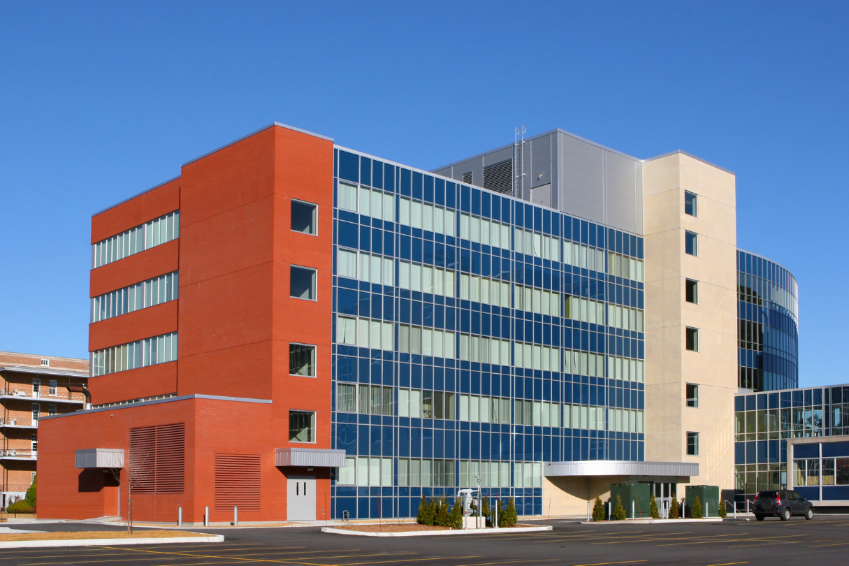 A large red brick building with many windows, treated with solar film in San Antonio.