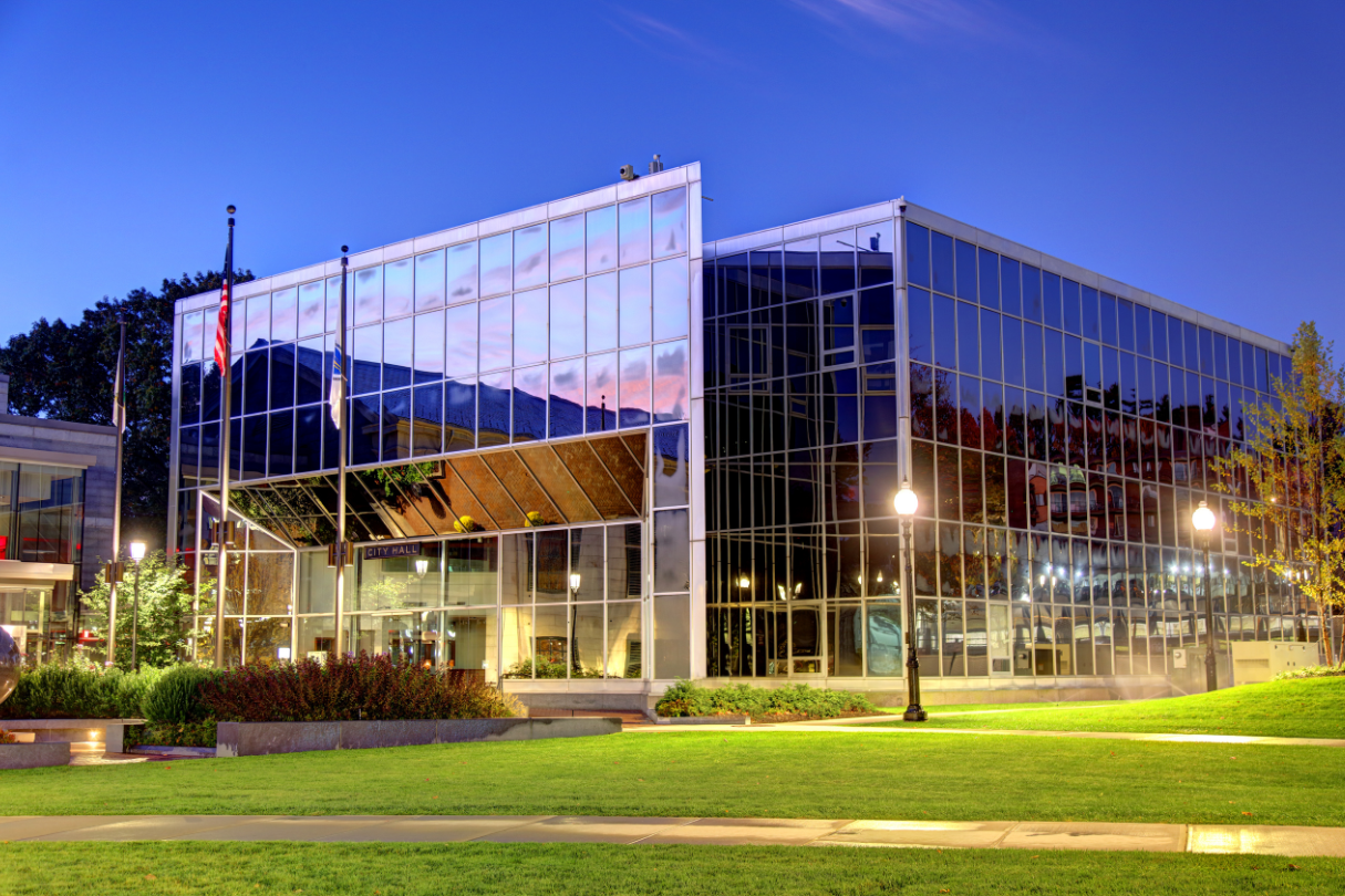 A large glass building with many windows lit up at night, with security film for windows.