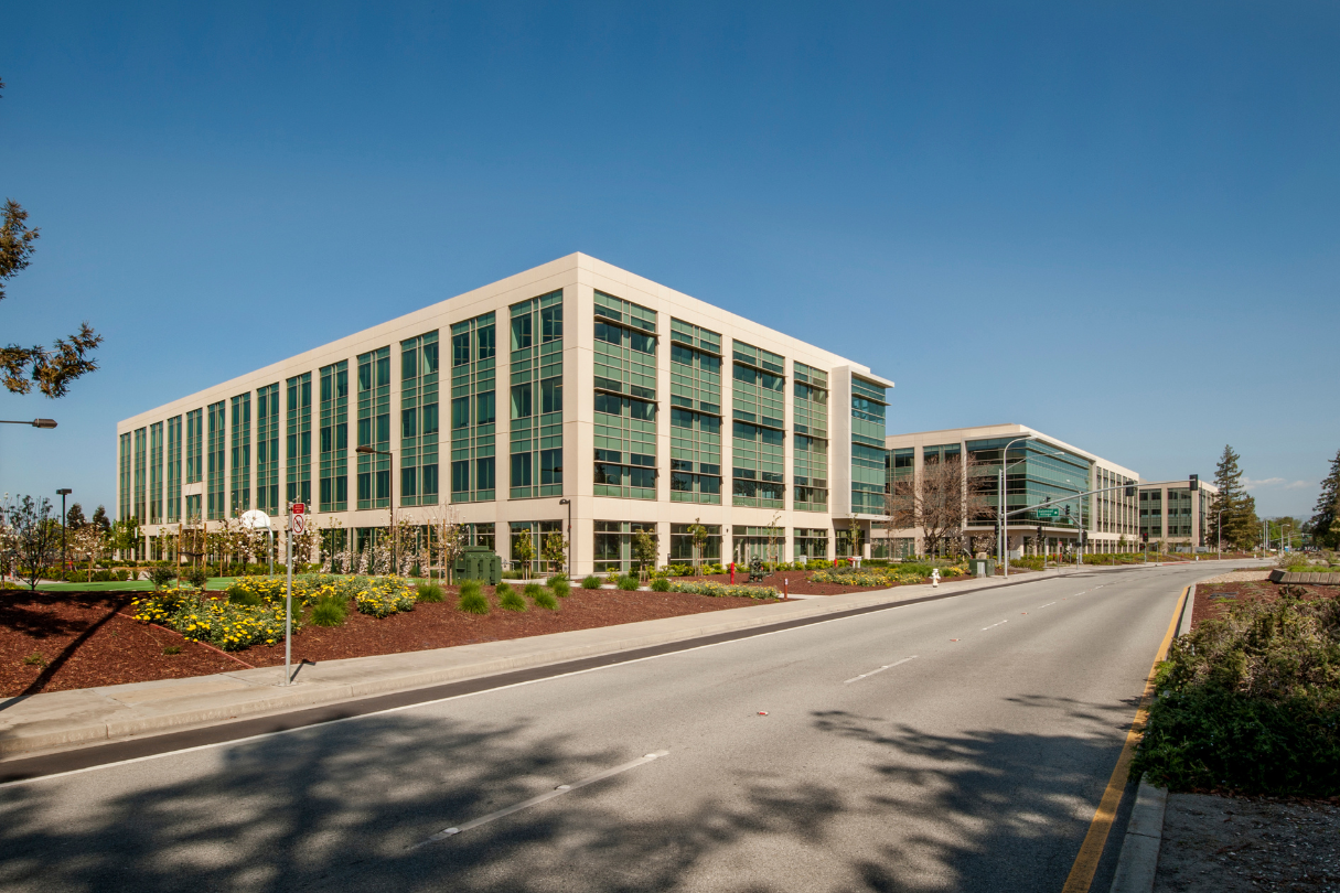 A large building with many windows next to a road, with security film San Antonio applied.