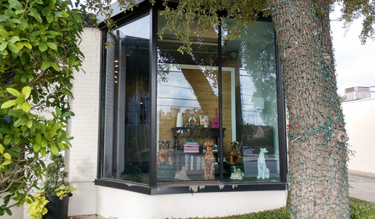 Storefront featuring a large window displaying 3M Window Film, with a tree positioned nearby.