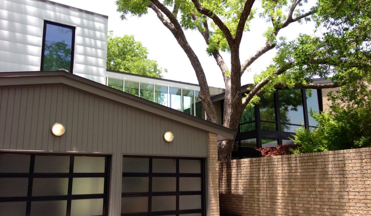 A house with a garage and a tree in front of it