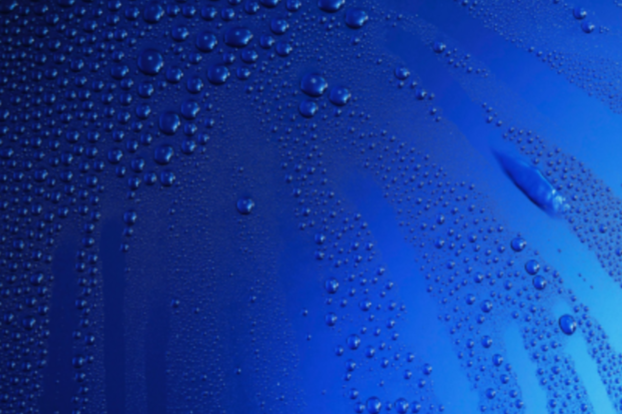 The hood of a blue vehicle showing water beading from a hydrophobic finish with ceramic coating in San Antonio.
